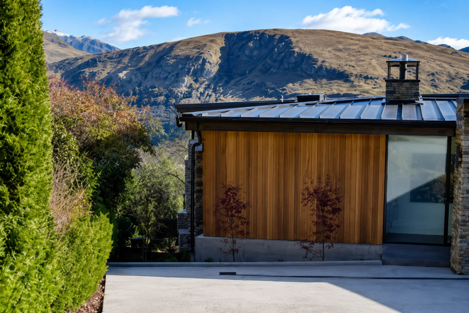 Repainted exterior with dark cladding and timber entry