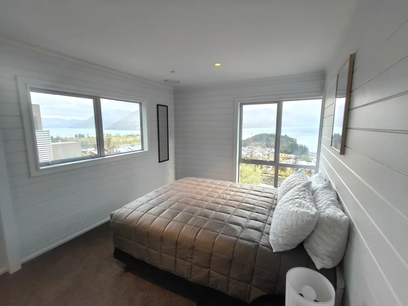 Bedroom with shiplap walls and a lake view