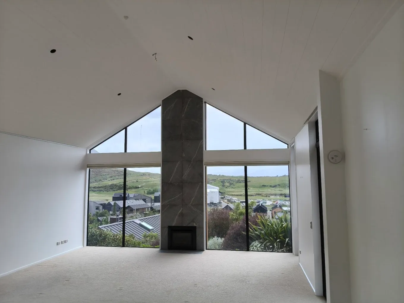 Vaulted living room with stone fireplace and mountain outlook