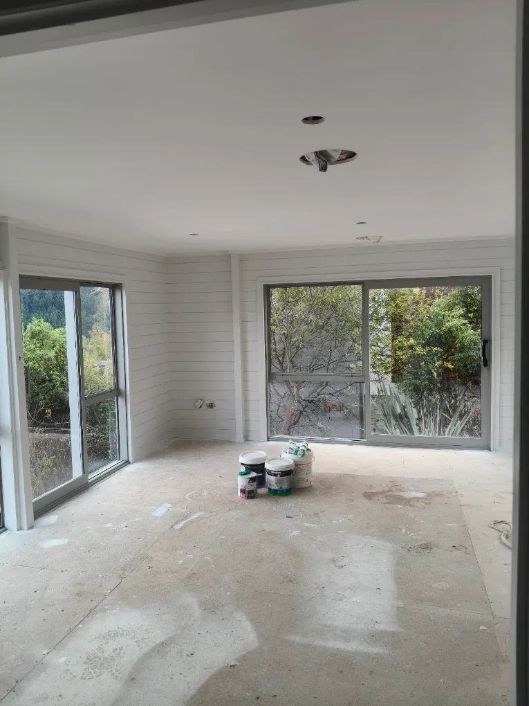 Empty room with drop sheets down mid-repaint